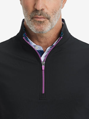 Close-up from nose to chest, showing collar detail and zipper of the black golf vest.