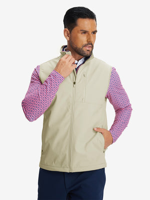Model front half-body shot with one hand in pocket wearing sleeveless softshell fleece outdoor vests with 6 pockets in light khaki