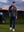Model holding jacket collar on course, golf fleece winter puffer jackets with bold black look