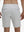 Back lower body shot of model wearing khaki grey breathable running shorts with 4 zipper pockets