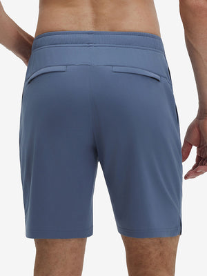 Back lower body shot of model wearing misty blue breathable running shorts with 4 zipper pockets