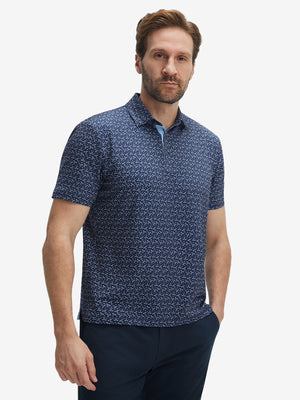 Front half-body shot of model wearing the dark blue golf club 4 way stretch print collared polo shirt for a casual sporty look