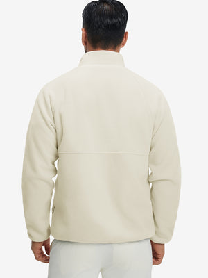 Back view of the model in the reversible fleece jacket with 5 pockets in beige.