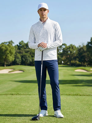 Model leaning on golf club on the course wearing full print lightweight quarter zip pullover in grey irregular shape