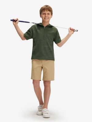 Full-body shot of model holding a golf club in military green water-resistant short sleeve q-zip hoodie for boys