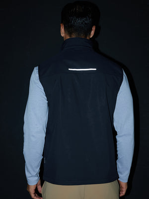 Model back half-body shot showcasing sleeveless softshell fleece outdoor vests with 6 pockets in navy