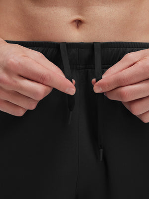 Detail view of elastic waistband on black breathable running shorts with 4 zipper pockets