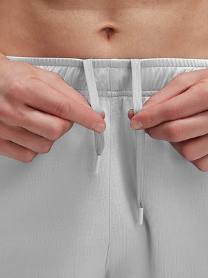 Detail view of elastic waistband on khaki grey breathable running shorts with 4 zipper pockets