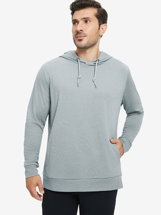 Model with one hand in pocket, wearing classic heather pullover hoodie in lunar rock melange, relaxed look.