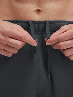 Detail view of elastic waistband on dark grey breathable running shorts with 4 zipper pockets