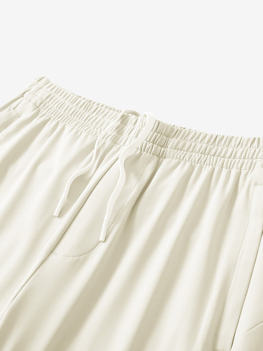 Angled view of lightweight women's stretchy joggers sweatpants waistband displayed in cream.