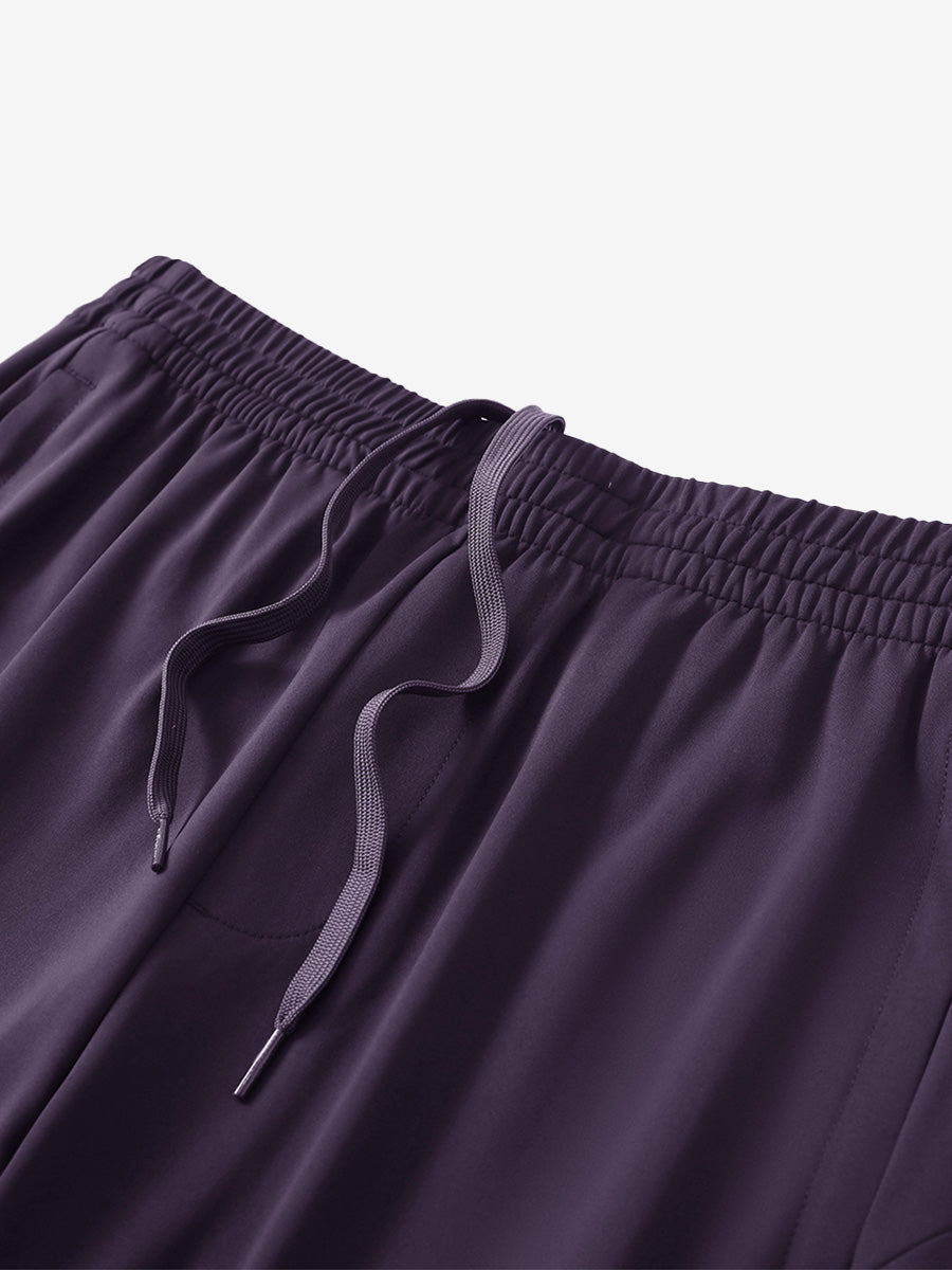 Angled view of lightweight women's stretchy joggers sweatpants waistband displayed in dark purple.