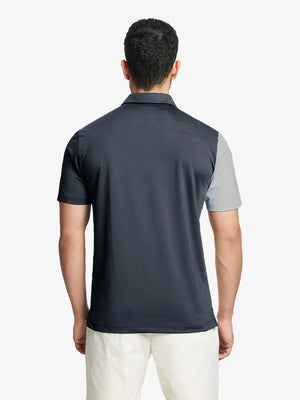 Back half-body view of model in DARK GREY Moisture Wicking Color Block Polo Shirt.
