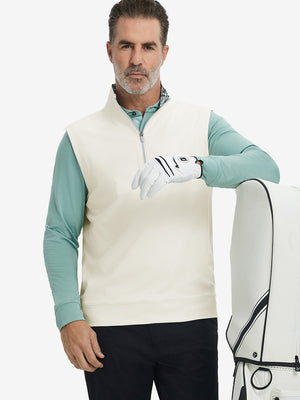 Model carrying golf bag, styled in cream print collar quarter zip golf vest, relaxed sporty fit.