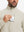 Close detail of hand in chest pocket of water-resistant zip up golf jacket in light khaki.