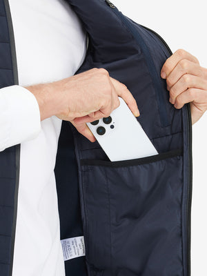 Inner pocket detail of Lightweight Water Resistant Puffer Vest in navy, holding smartphone