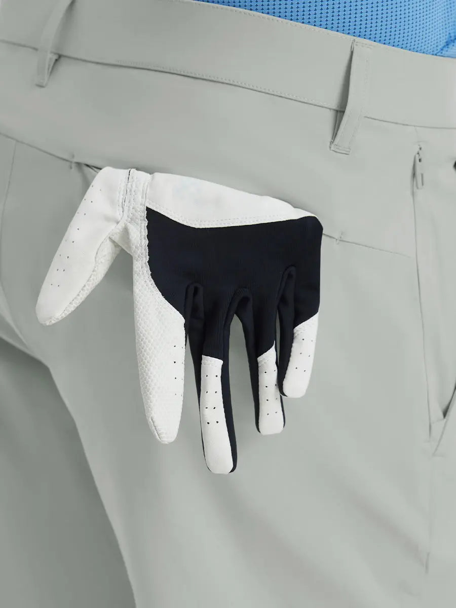 Back view of Player Fit Versatile Solid Shorts 9 Inch with golf glove tucked into right pocket – NEUTRAL GREY