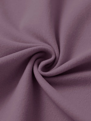 Fabric close-up of light pinkish purple women's water-resistant stretch fleece lined jacket, soft stretch fabric with fleece lining.