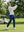 Model swinging on golf course wearing full print lightweight quarter zip pullover in white polka dots