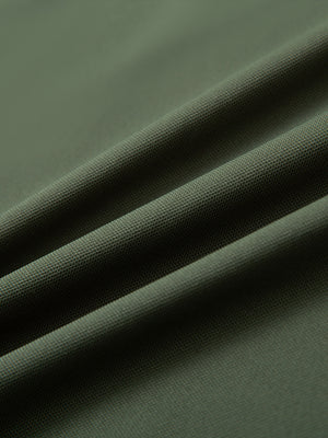 Close-up of olive green ventilated pique performance polo fabric showing breathable texture.