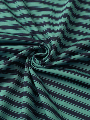 Close-up of turquoise navy yarn dyed stripe polo fabric showing distinct woven stripes and textured surface.