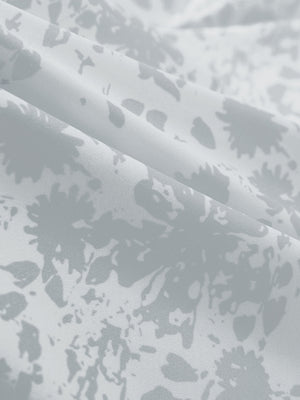 Close-up of grey splatter stretch printed collarless henley golf shirts, showcasing texture and print details.