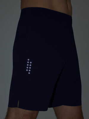 Detail of glow in the dark feature on navy  breathable running shorts with 4 zipper pockets