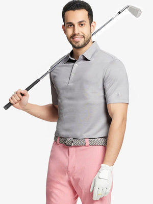 Front half-body shot of model holding golf club wearing Ventilated Heather Jacquard Polo – FADED DENIM HEATHER