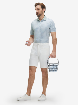 Full front: model in bluish abstact lightweight stretch upgraded print golf polo shirts holding golf ball.