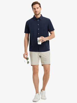 Detail shot with model holding a takeaway drink and sunglasses, featuring the NAVY polo’s side vent.